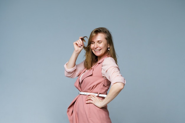 Positieve emoties portret van opgewonden blanke vrouw in roze kleren schreeuwen van vreugde grijze achtergr...