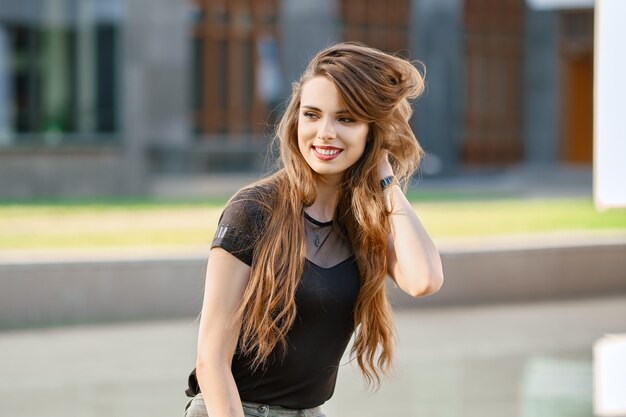 Positieve en gelukkige jonge vrouw met lang krullend haar