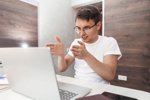 Positieve jongeman videochatten met laptop