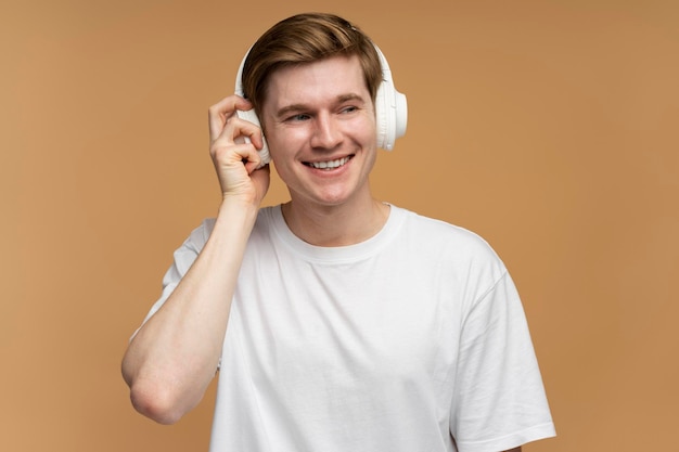 Positieve man die naar muziek luistert met een koptelefoon en danst