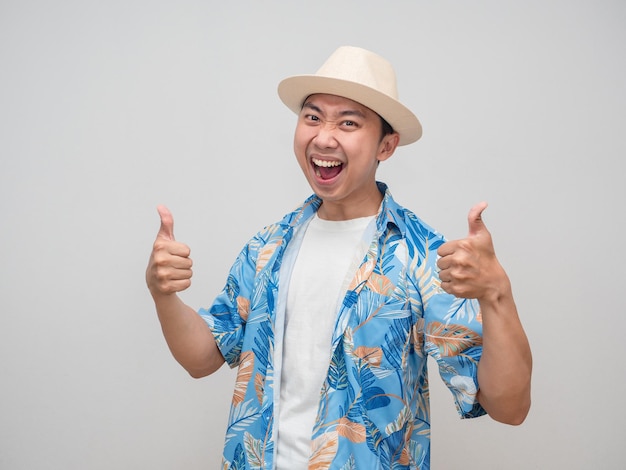 Positieve man draagt hoed strandshirt zachte glimlach dubbele duim omhoog