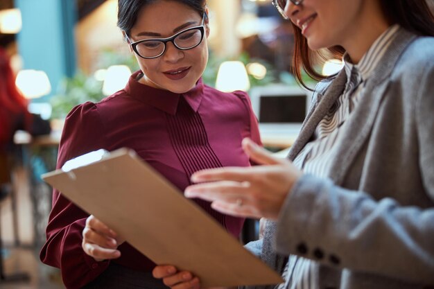 Positieve opgetogen internationale vrouw die naar het tijdschema kijkt