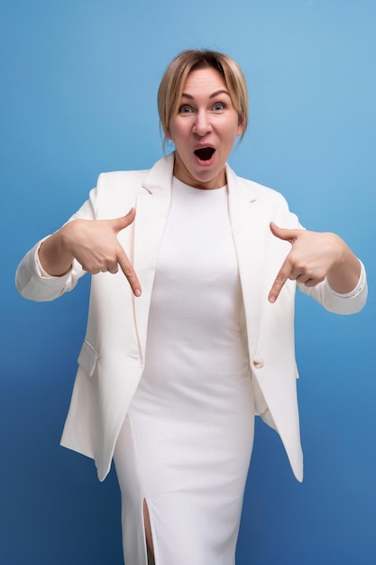 Positieve slanke jonge blanke blonde dame in witte jas en jurk deelt ideeën