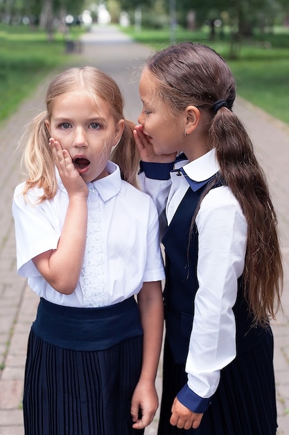 Positieve stemming. tienermeisjes met rugzakken wandelen in het park. terug naar school. tiener kinderen met rugzak. begrip vriendschap. beste schoolvrienden. met plezier naar school gaan. schoolmeisjes met rugzak