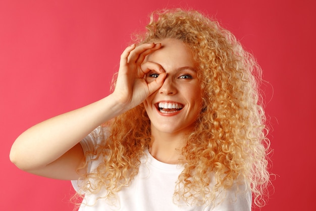 Positieve vriendelijke jonge vrouw die ok teken toont