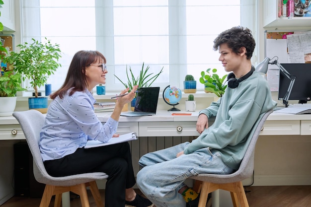 Positieve vriendelijke vrouwelijke psycholoog die met een jonge man praat.