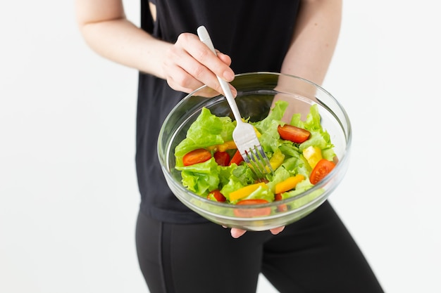 Positieve vrouw die een lichte Griekse salade eet