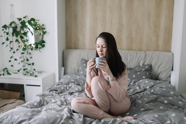 Positieve vrouw met kussen die thuis in bed zit Zoete dromen goedemorgen nieuwe dag weekend vakantie concept