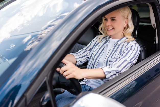 Positieve vrouw zit in de auto tijdens rijlessen