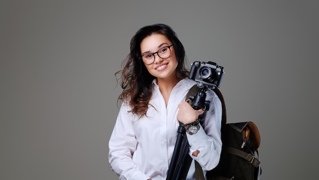 Positieve vrouwelijke toerist met fotocamera en reisrugzak.