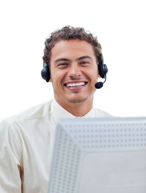 Positieve zakenman die op hoofdtelefoon bij een computer spreekt