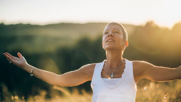 Positieve zonneschijn Opmerkzame vrouw die van zonlicht geniet en de positieve gevoelens omarmt die door zonneschijn zijn gecreëerd