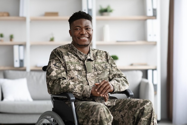 Photo positive african american military man sitting in wheelchair clinic interior