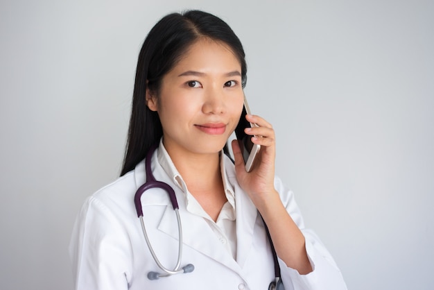 Positive Asian Female Physician Speaking on Phone