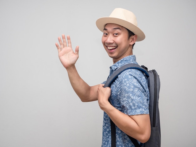 Позитивный азиатский путешественник оборачивается и говорит hiTourism man hello