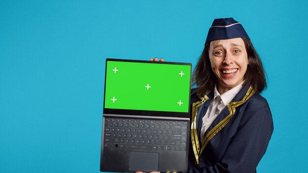 Positive aviator showing laptop with greenscreen person