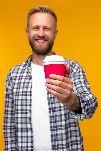 Positive bearded man with takeaway coffee