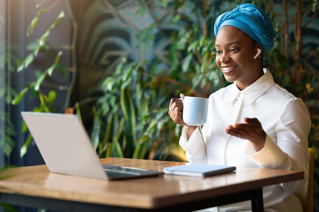 Positive black woman have online meeting working at cafe