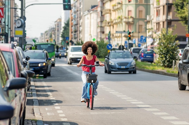 写真 街の通りで自転車に乗るポジティブな黒人女性