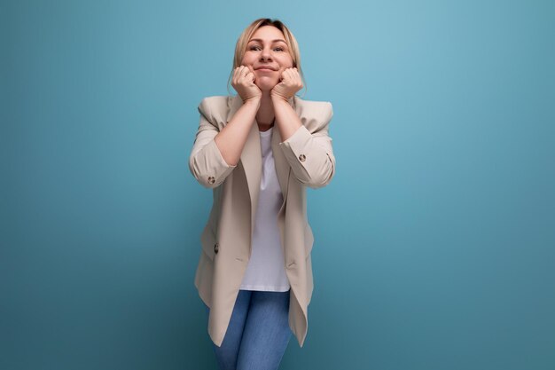 Positive blonde young woman in casual style on studio background