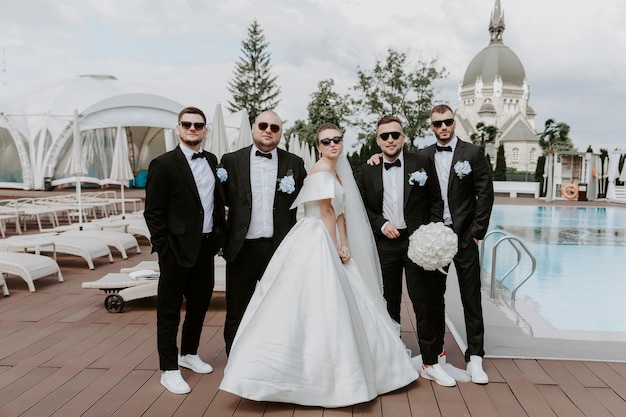 Positive bride and groomsman in sunglasses . Best friends on wedding.