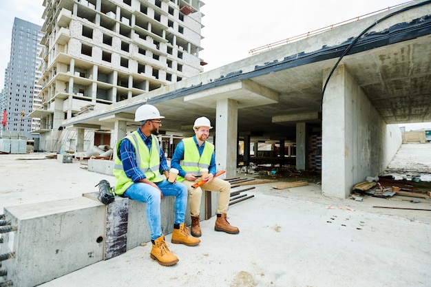 Positive builders relaxing on construction site