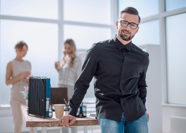 Positive business man sitting near the desktop