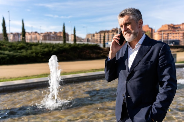 Positive businessman talking on smartphone