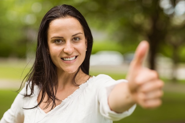 Foto bruna casuale positiva con i pollici su