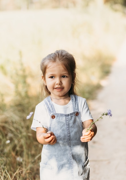 写真 夏の晴れた日、表情の感情を楽しんで、楽しんで、夏の日に歩く幸せな子供を楽しんでいるポジティブな魅力的な少女