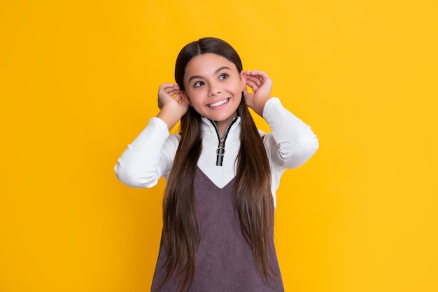 Positive child with long hair on yellow background