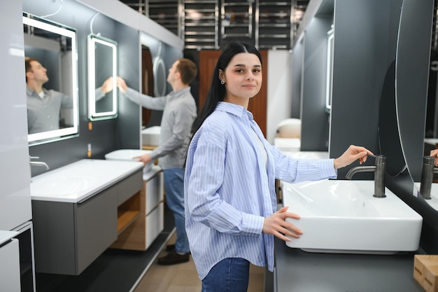 Positive couple choosing wash basin in bathroom furniture shop