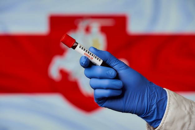 A positive COVID-19 blood test against the White-Red-White flag of Belarus.