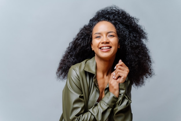 Positive curly woman with luminous hair and casual clothing