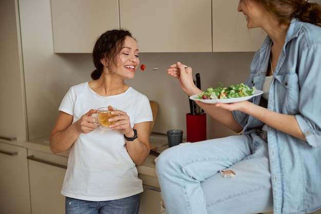 Positive delighted brunette going to eat tomato