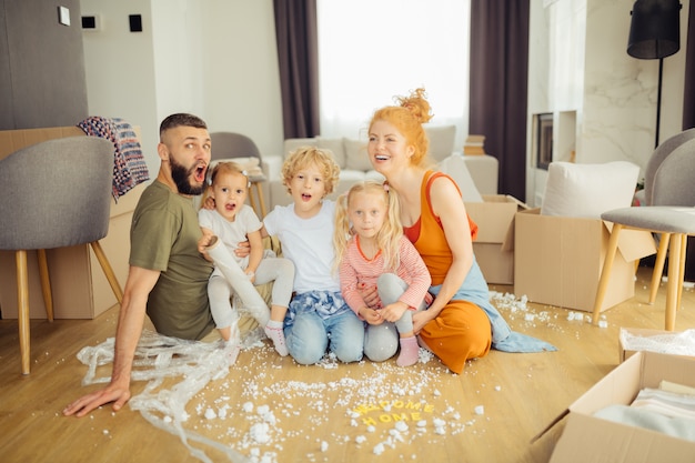 Famiglia felice positiva che si trasferisce in una nuova casa