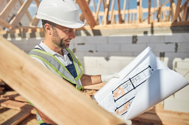 Positive delighted male person looking at sketch