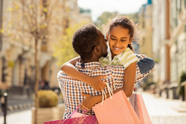 Positive delighted teenager embracing her young dad