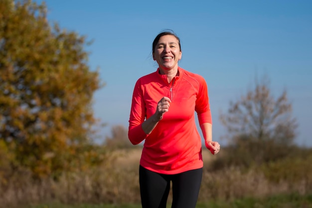 Positive elderly woman is doing exercises Portrait of a sporty elderly woman in the park