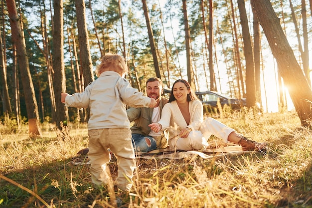 Positive emotions Happy family of father mother and little daughter is in the forest