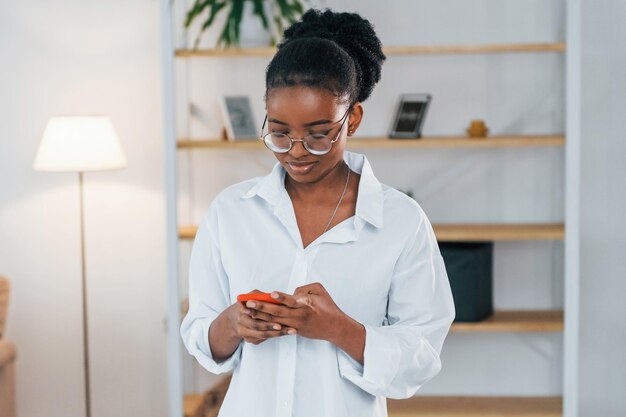 Positive emotions young african american woman in white shirt\
is at home