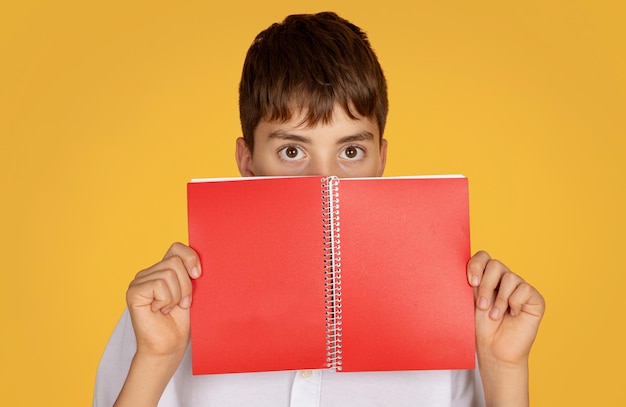 Positive european teenager schoolboy reading book at school