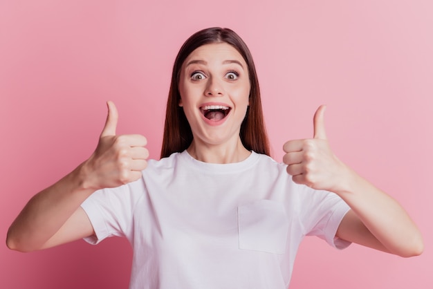 Positive excited crazy promoter girl raise thumb up open mouth smile on pink background