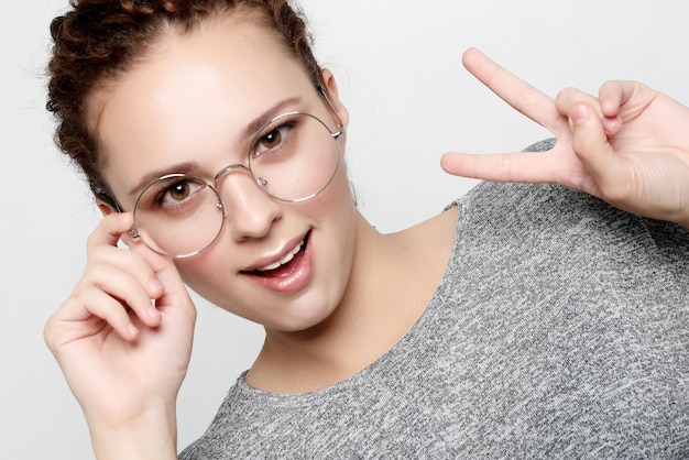 Photo positive female student wears grey sweater round glasses people studying success and achievements