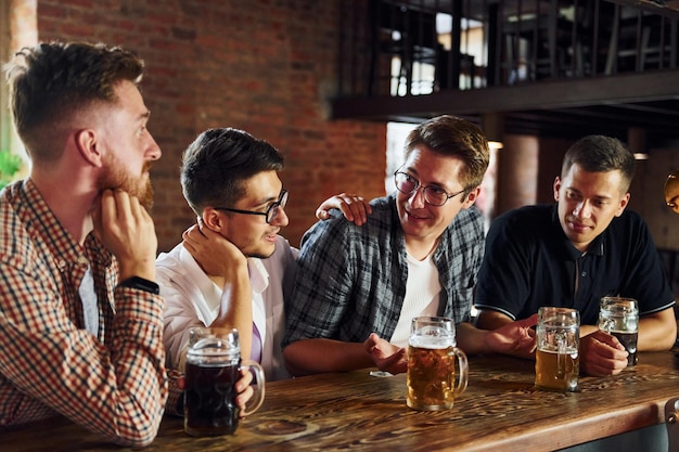 Positive friends People in casual clothes sitting in the pub