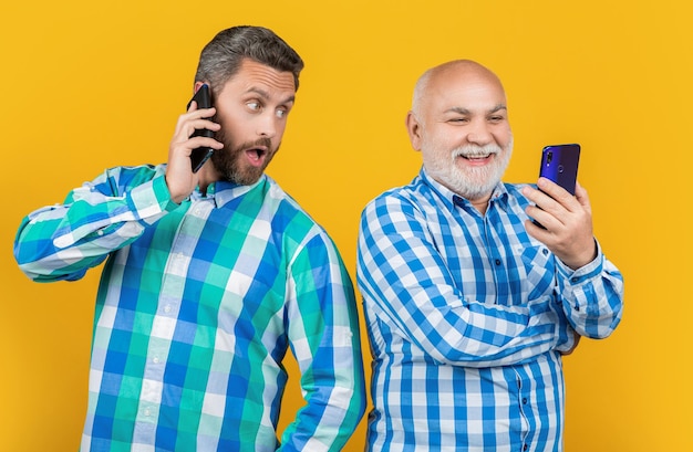 Positive generation men use phone isolated on yellow generation men use phone in studio