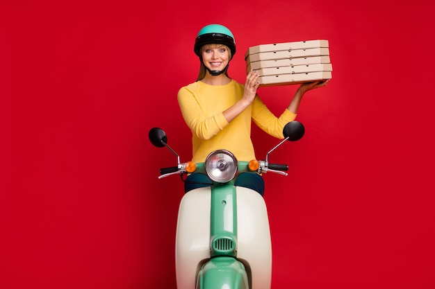 Positive girl girl bike driver courier hold pile stack pizza on red wall