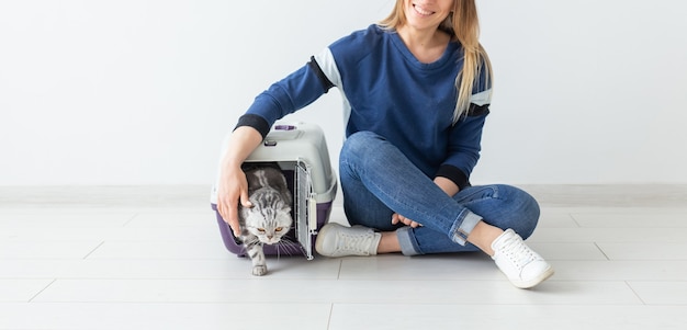 Positive good-looking woman and beautiful gray Scottish Fold cat into her new apartment after the