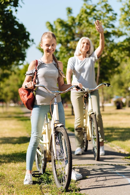 Nipote positiva e sua nonna nel parco in sella a biciclette