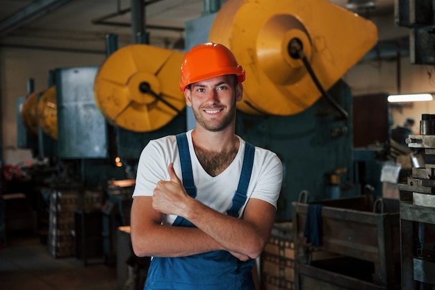 Positive guy. Portrait of engineer in metallurgical factory in protective helmet.